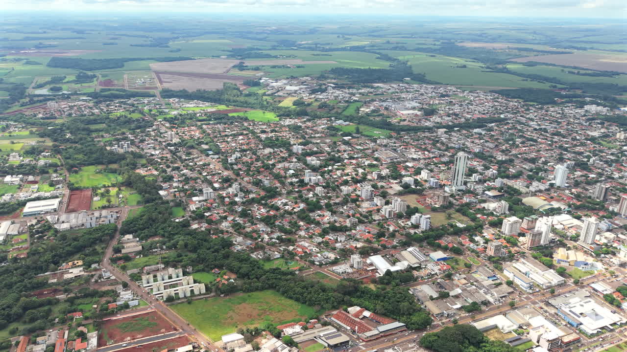 Aerial overview of suburban Vila Industrial area with green zones and surrounding farmlands, Toledo, Paraná, Brazil.