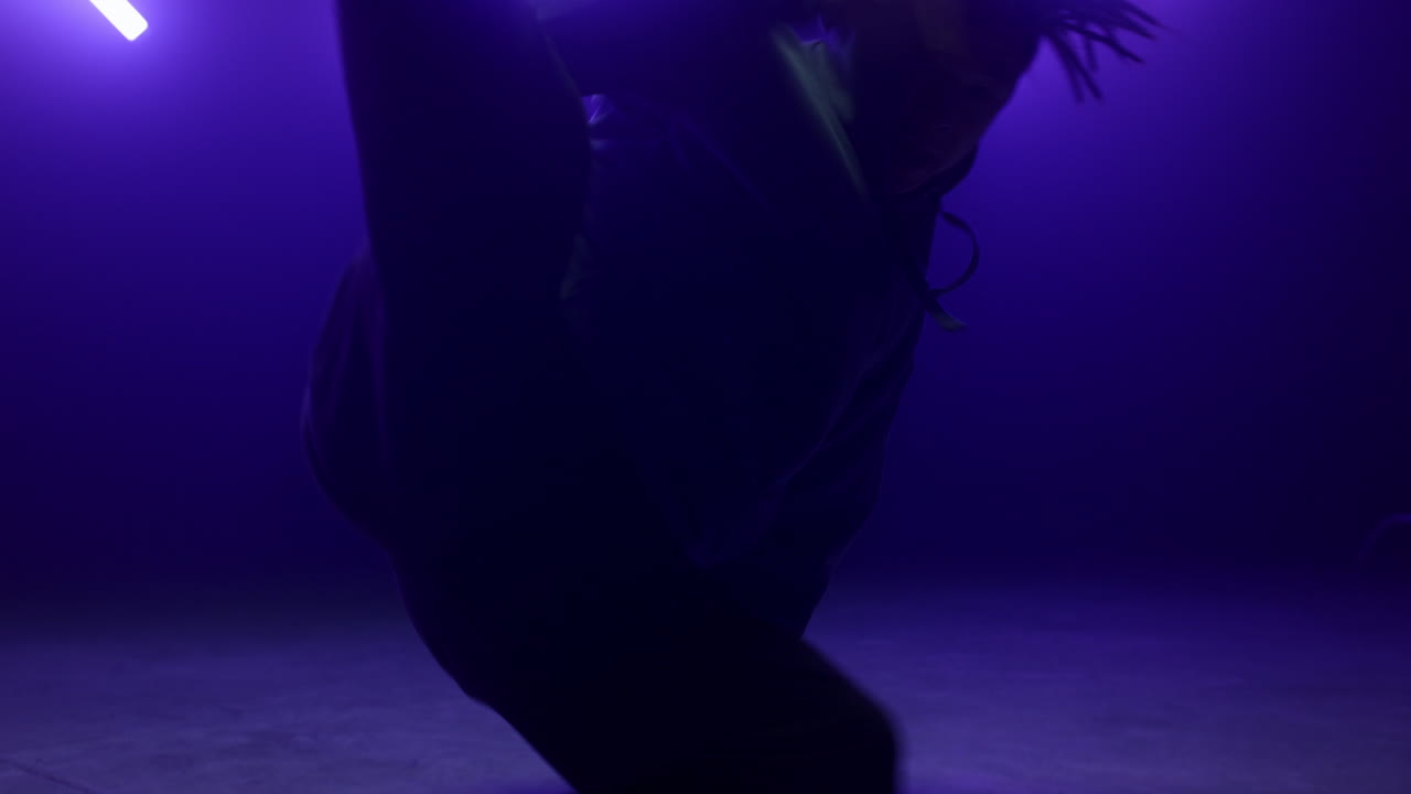 Dancer man performing breakdance in nightclub close up. Agile guy spinning body