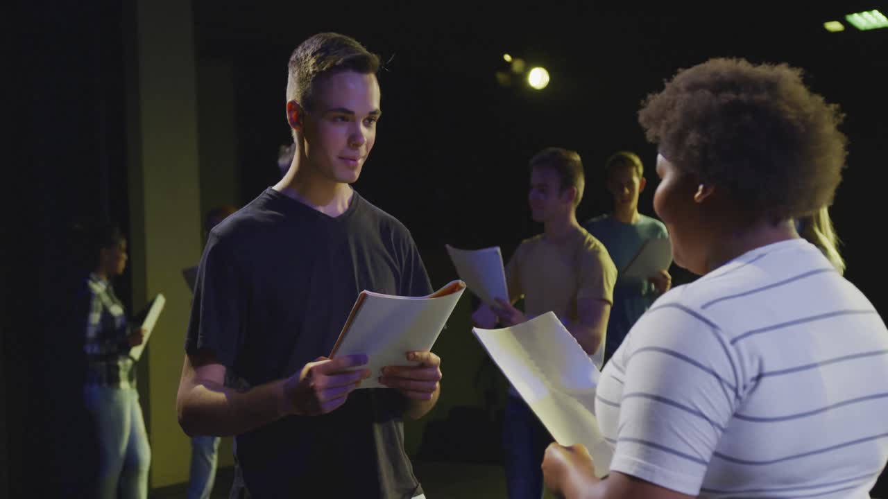 Students preparing before a high school performance in an empty school theater