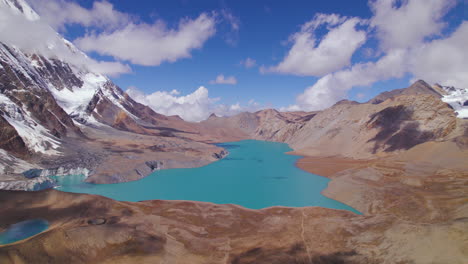 tomada de dron del lago más alto del mundo en el circuito de annapurna nepal, el lago de mayor altitud del mundo tilicho rodeado de montañas y nubes, lago azul, nieve, clima soleado aventura 4k