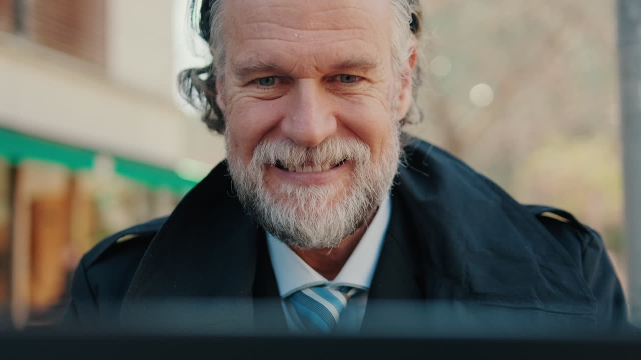 Smiling Business Man Working on Laptop at Cafe