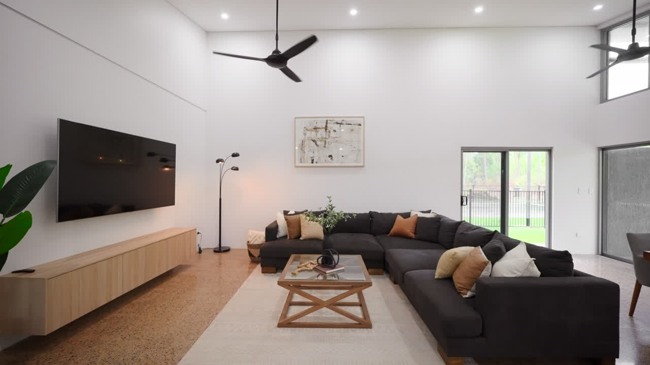 黒いソファー 木とガラスのコーヒーテーブル 大きなテレビ