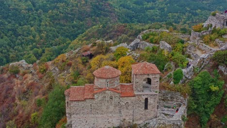 volando hacia abajo revelando la antigua fortaleza de asen en las montañas rhodope durante un colorido