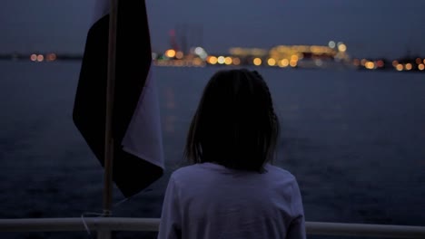Girl-looking-out-on-water-at-night