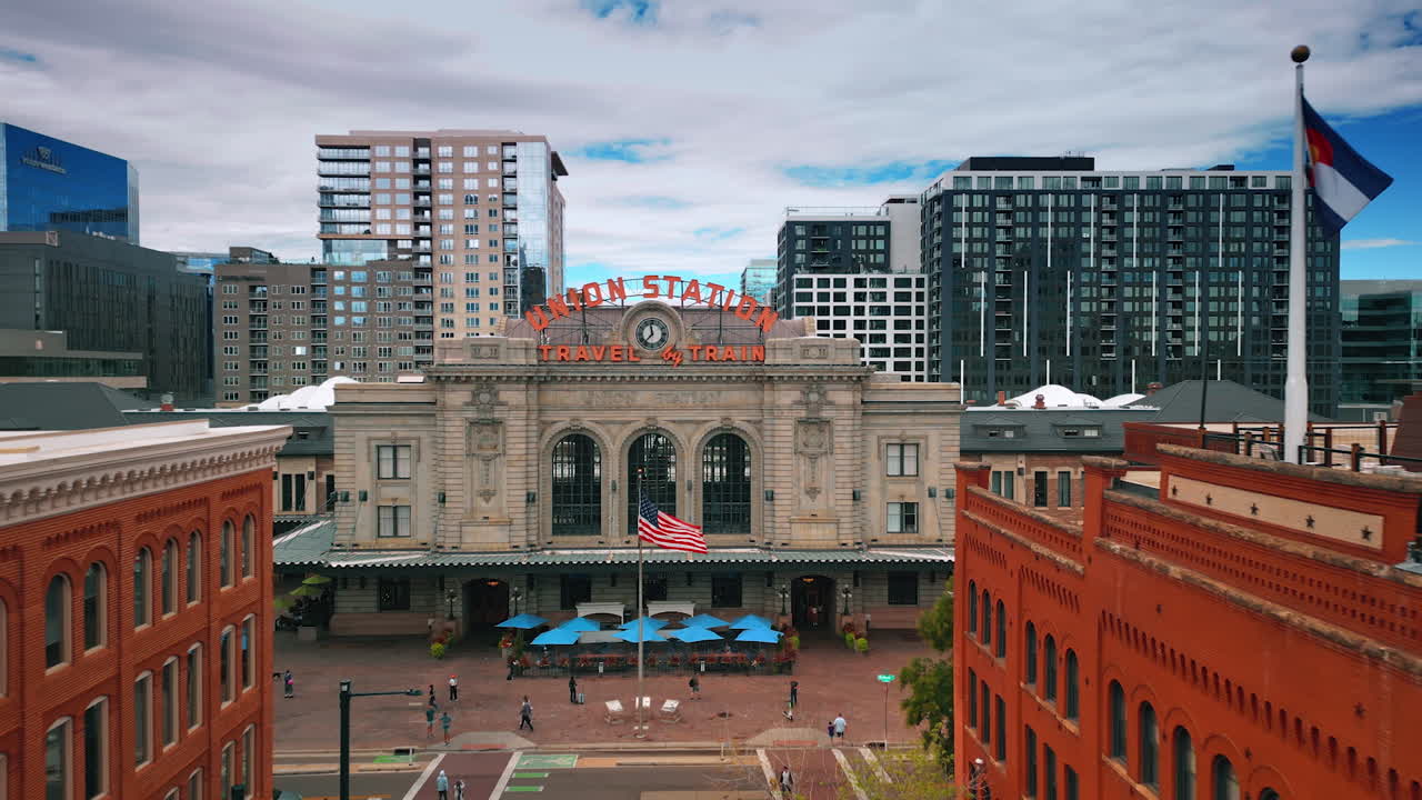 Denver, USA, 28 July 2025: Approaching the front façade of Denver Colorado Union Station. High-rises against gloomy sky at backdrop