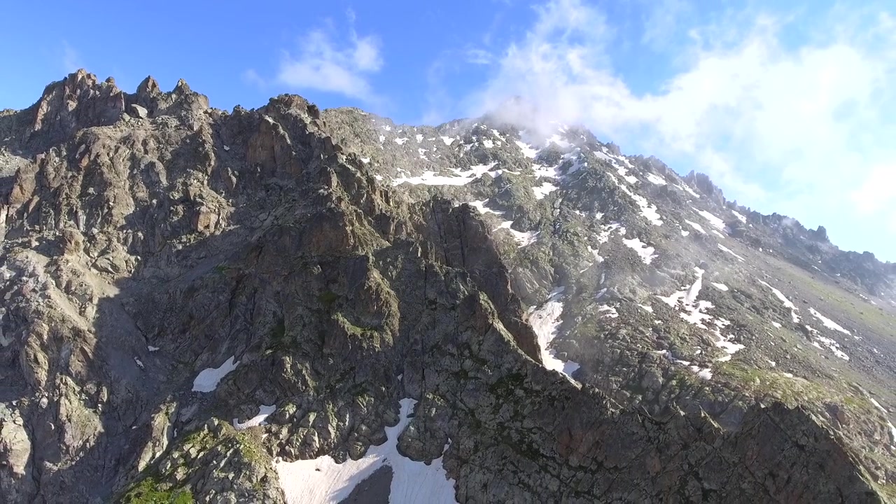 Vista Aerea di Cime Montuose Frastagliate con Neve e Nuvole