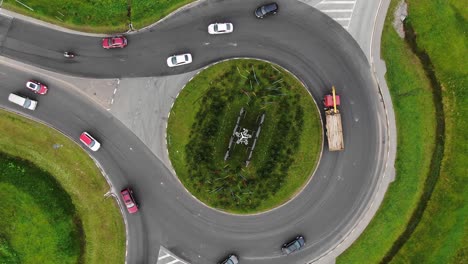 cars drive around large turning circle in rural area