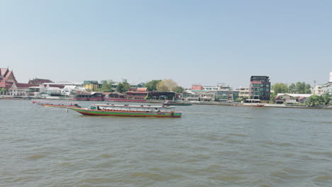 barcos de pasajeros del río chao phraya cerca del templo en bangkok, tailandia
