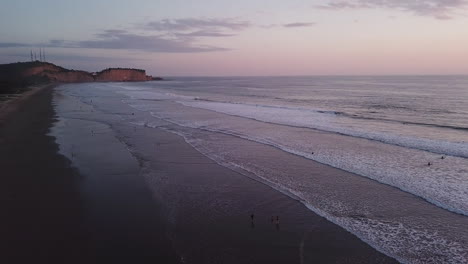 Playa-De-Olon,-En-Ecuador---Olas-Salpicando-En-La-Orilla-Durante-La-Puesta-De-Sol---Hermoso-Destino-Turístico---Toma-Aérea