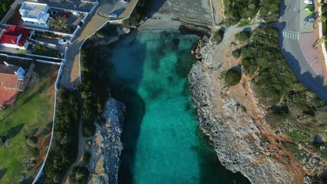 Filmischer-Drohnenflug-über-Strandgrundstück-In-Sa-Caleta,-Insel-Menorca,-Spanien