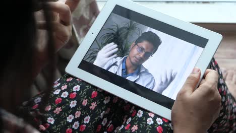 mujer teniendo una consulta virtual con un médico en una tableta