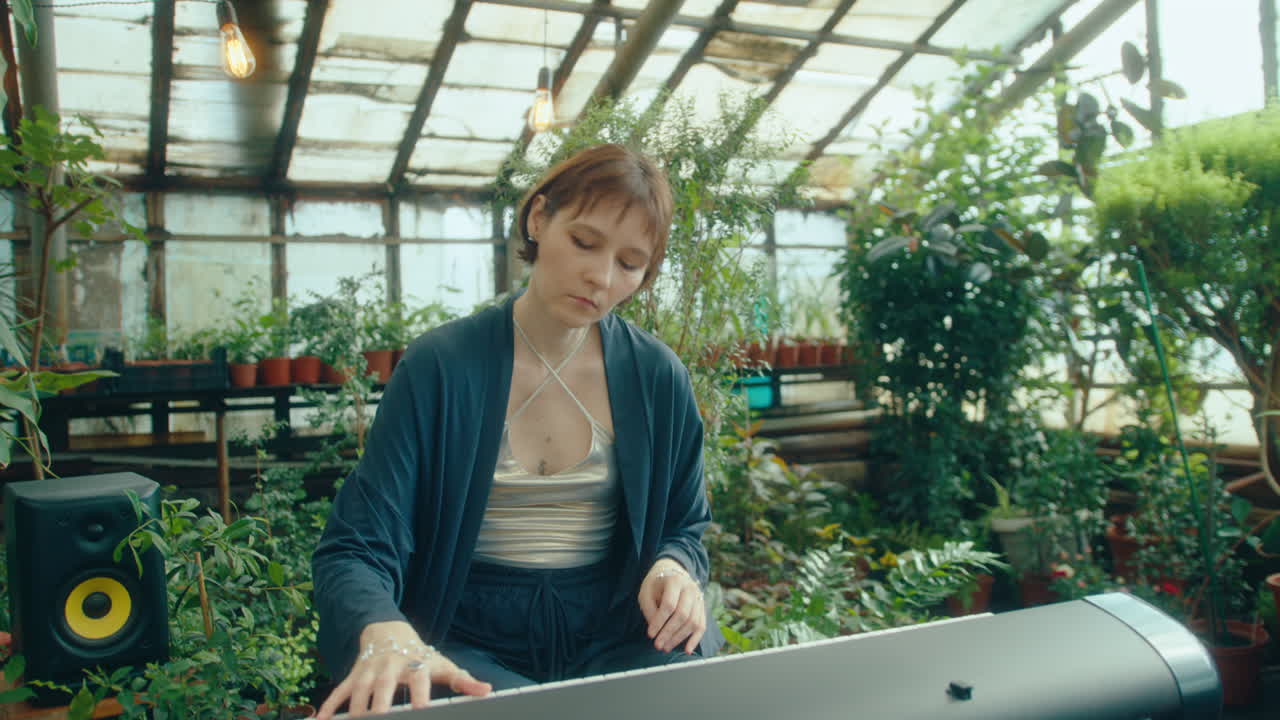 Woman Playing Musical Keyboard in Indoor Garden Full of Lush Plants