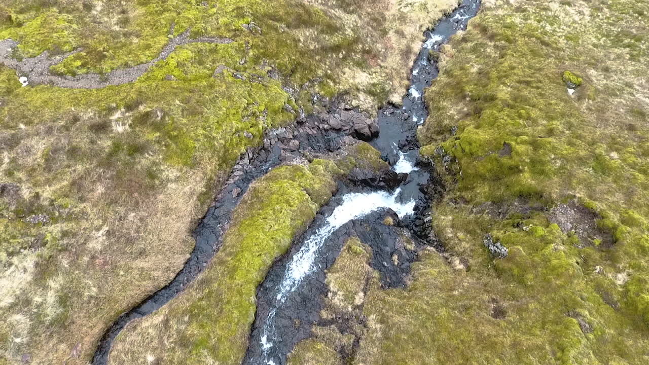 Ripresa con drone con inclinazione verso il basso di una piccola cascata islandese