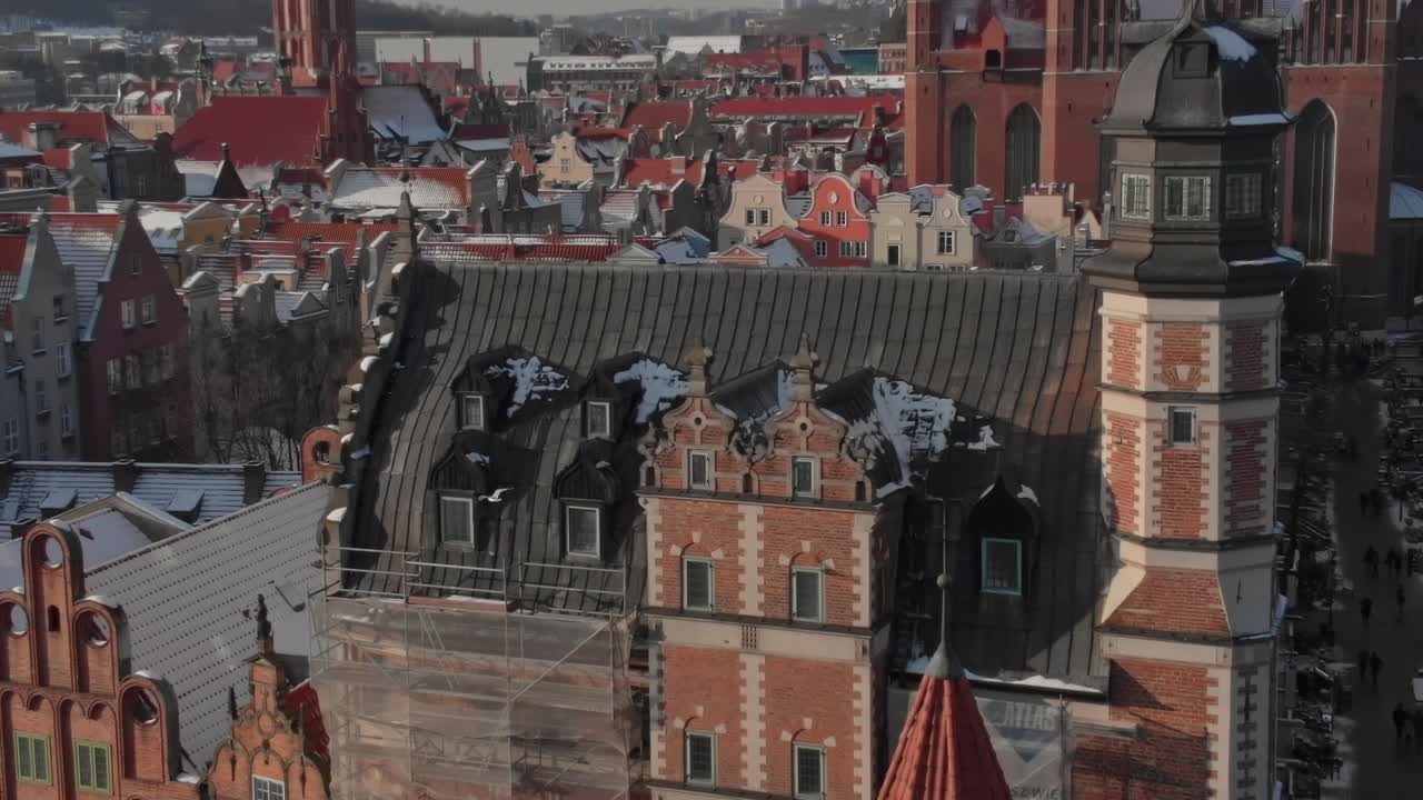 Zimní pohled na staré budovy v Gdaňsku, Polsko se sněhem na střechách.