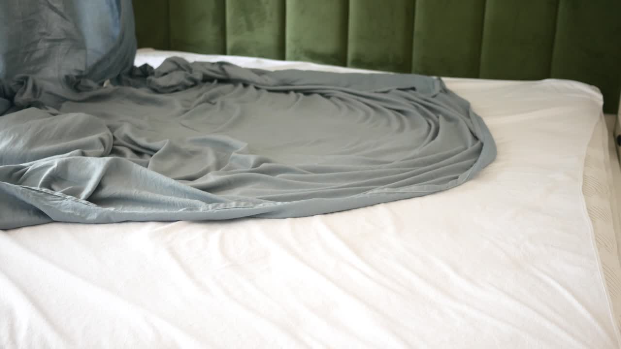 회색 시트 로 침대 를 짓는 것