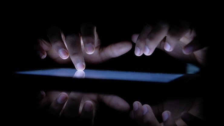 Mani che usano un tablet di notte