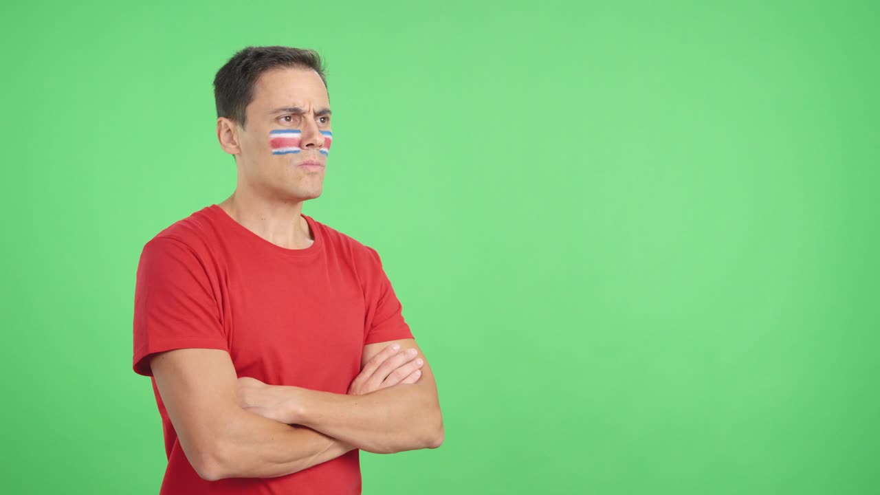 Man with costa rican flag painted looking away with serious expression