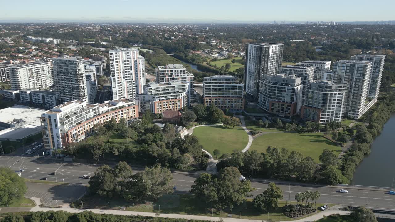 toma aérea volando hacia atrás a lo largo de los apartamentos residenciales en el suburbio de sydney con edificios altos y parque en el fondo, hermoso día de verano con árboles verdes brillantes
