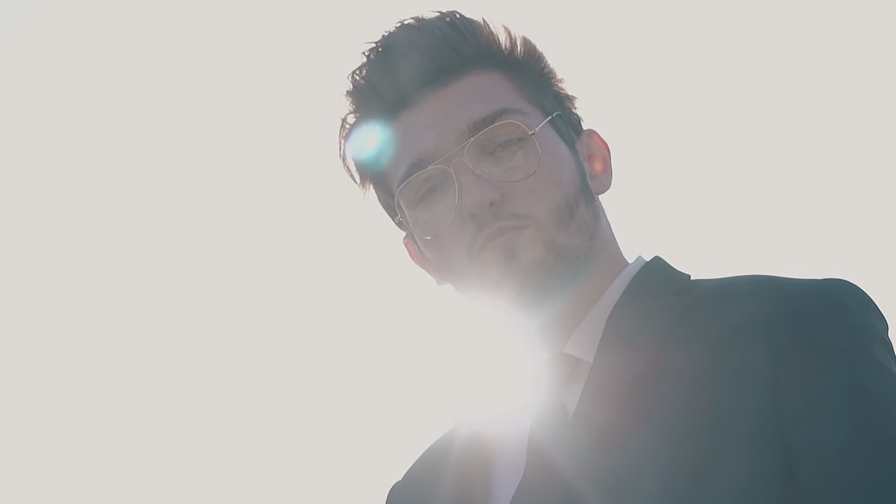 값비싼 슈트를 입은 사업가가  ⁇ 빛 속도를 늦춰서 서 있습니다.