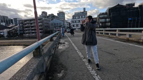 people walking across a bridge in a city