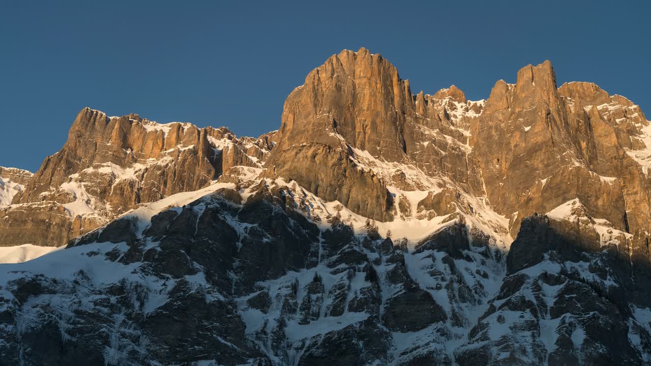 눈이 내린 아름다운 겨울 풍경에서 해가 뜨면 산맥과 산꼭대기를 볼 수 있습니다. 태양은 산을 위에서 아래로 비추고 빛으로 나타납니다.