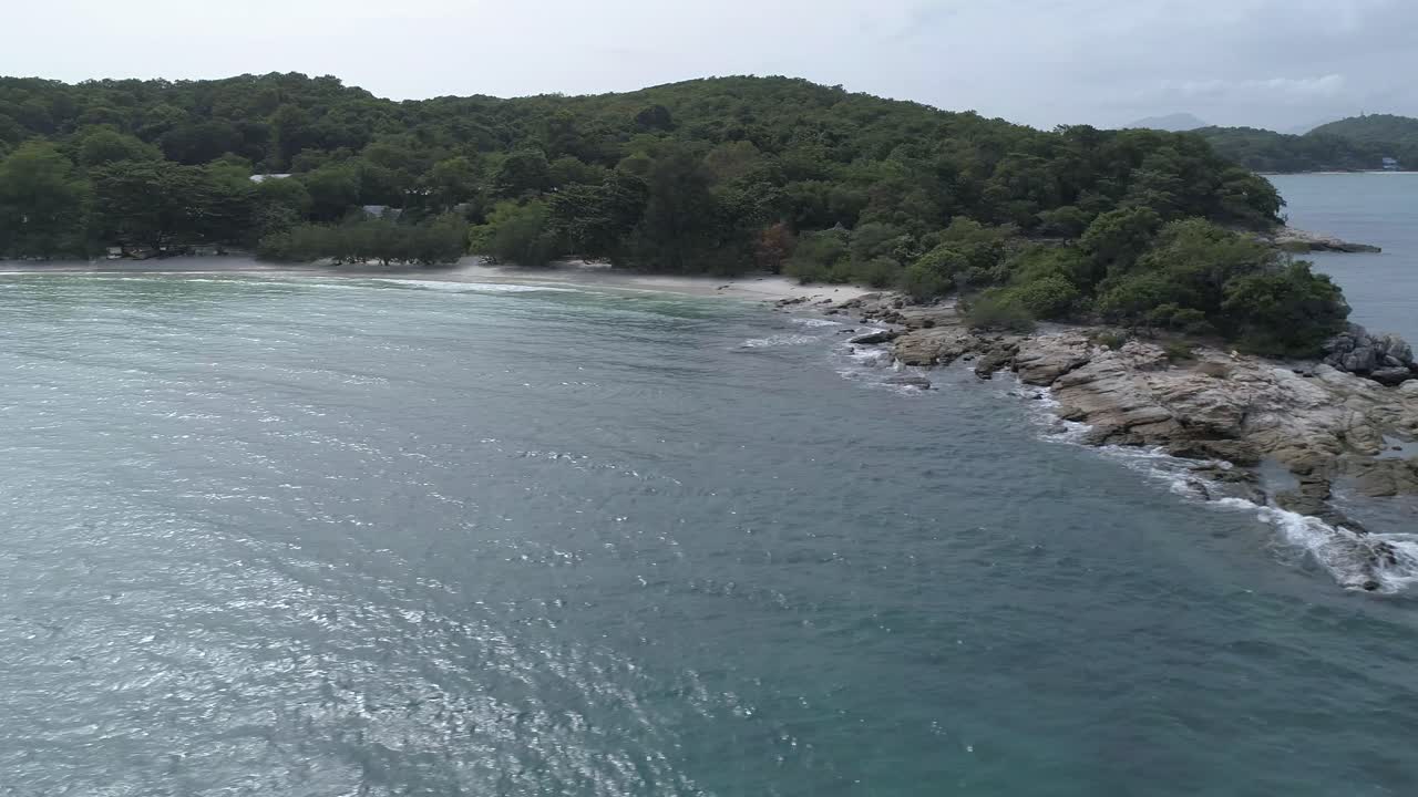 바위가 많은 노두, 작은 어선, 바다 위의 드론 비행