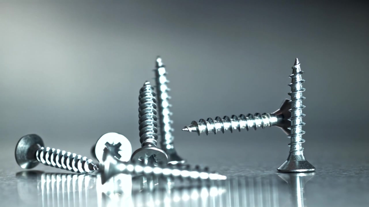 Metal Screws Falling in Slow Motion onto a Reflective Surface