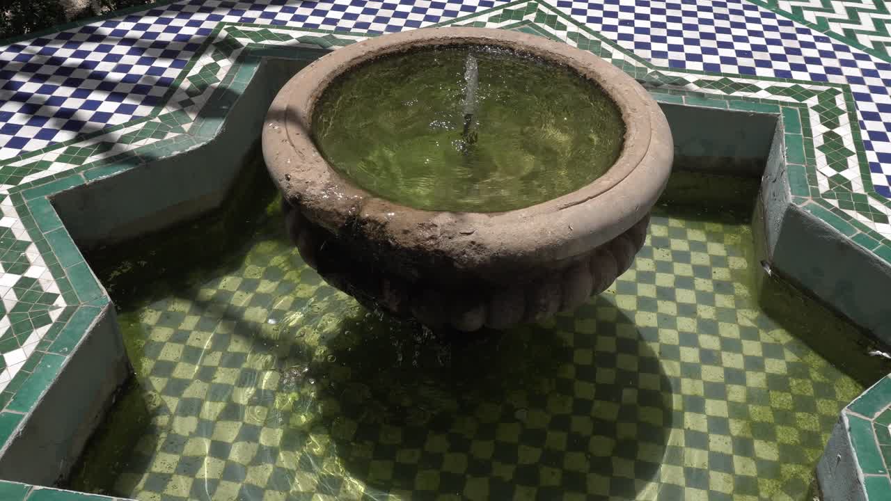 A simple water fountain in the middle is surrounded by a really cool Moroccan tile pattern on the floor