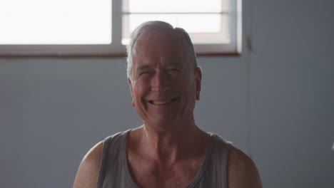 Senior-man-smiling-at-camera-at-home