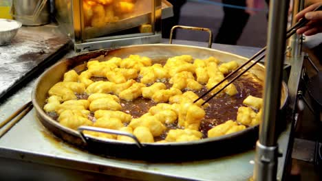 Frying-deep-fried-dough-stick-in-the-pan-at-Yaowarat-Road-Chinatown,-a-popular-travel-destination-in-Bangkok,-Thailand