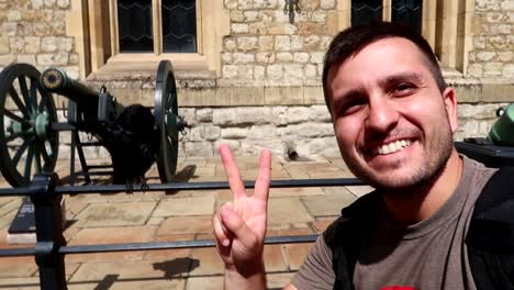 happy caucasian young man tourist smiling in the tower of london with a raven