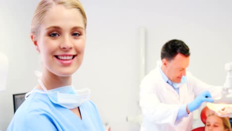 Portrait-of-smiling-nurse-standing-in-clinic