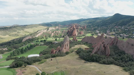 campo de golf de punta de flecha en littleton colorado con césped verde, rocas rojas y cielos azules