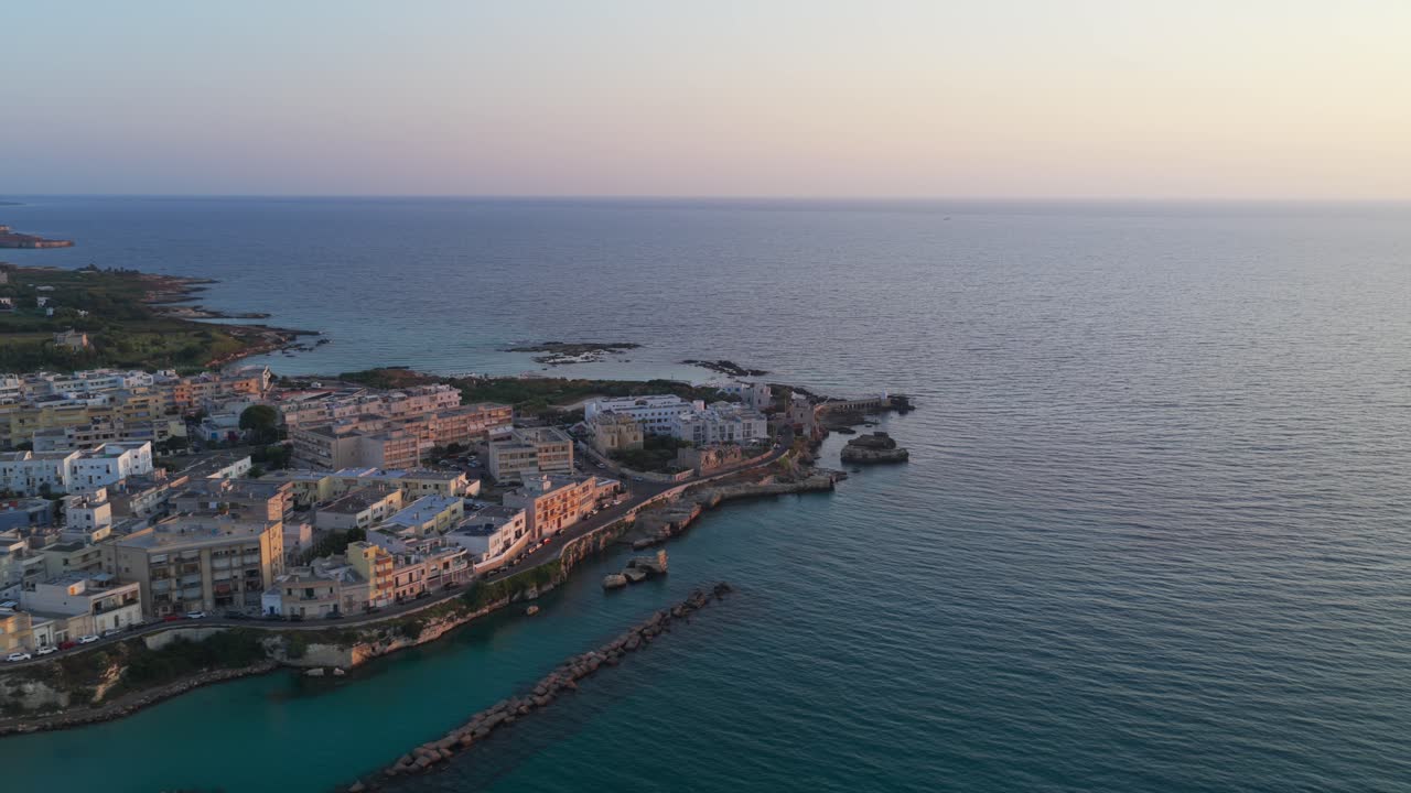 Aerial view of historic Otranto coastal town at sunrise. Shows old town, harbor with turquoise water, and Adriatic Sea. For travel or establishing shot use, Puglia, Italy