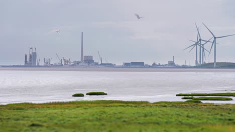 A-city-wrapped-in-haze-and-rotating-wind-turbines-on-the-Danish-coast