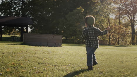 An-active-kid-runs-through-a-green-meadow-on-a-clear-autumn-day.