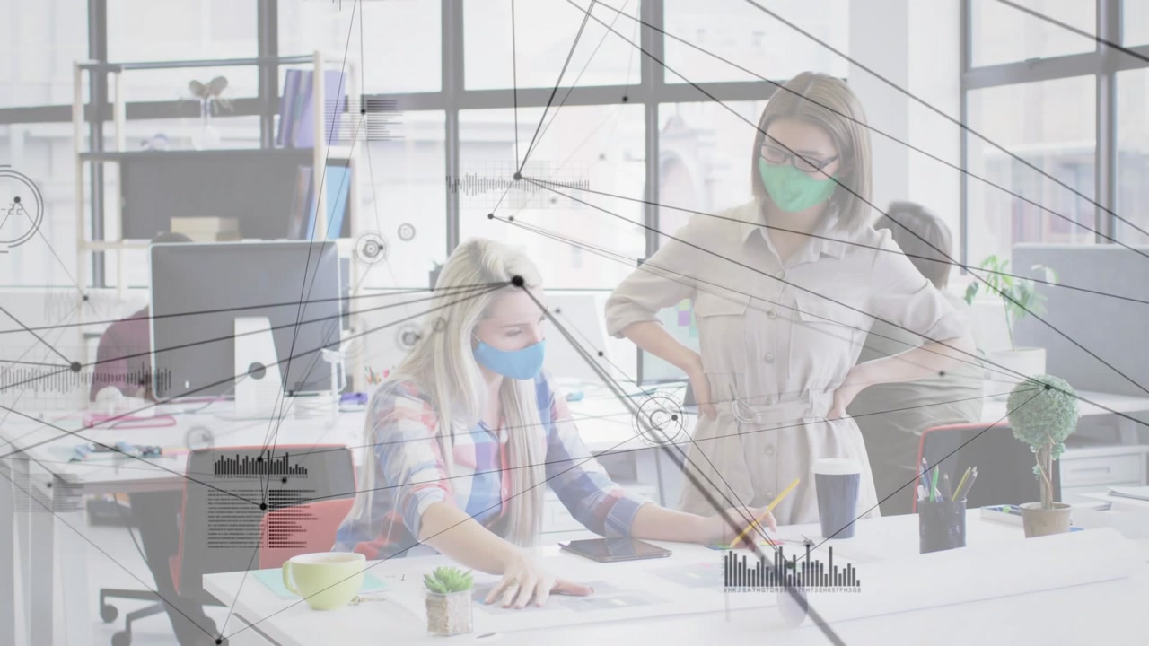 Seated woman pointing at plans and tapping tablet, causing HUD linking design nodes for review
