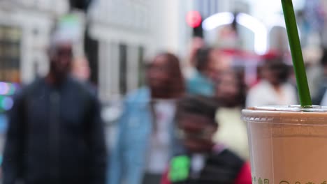 people walking past a drink on a busy street