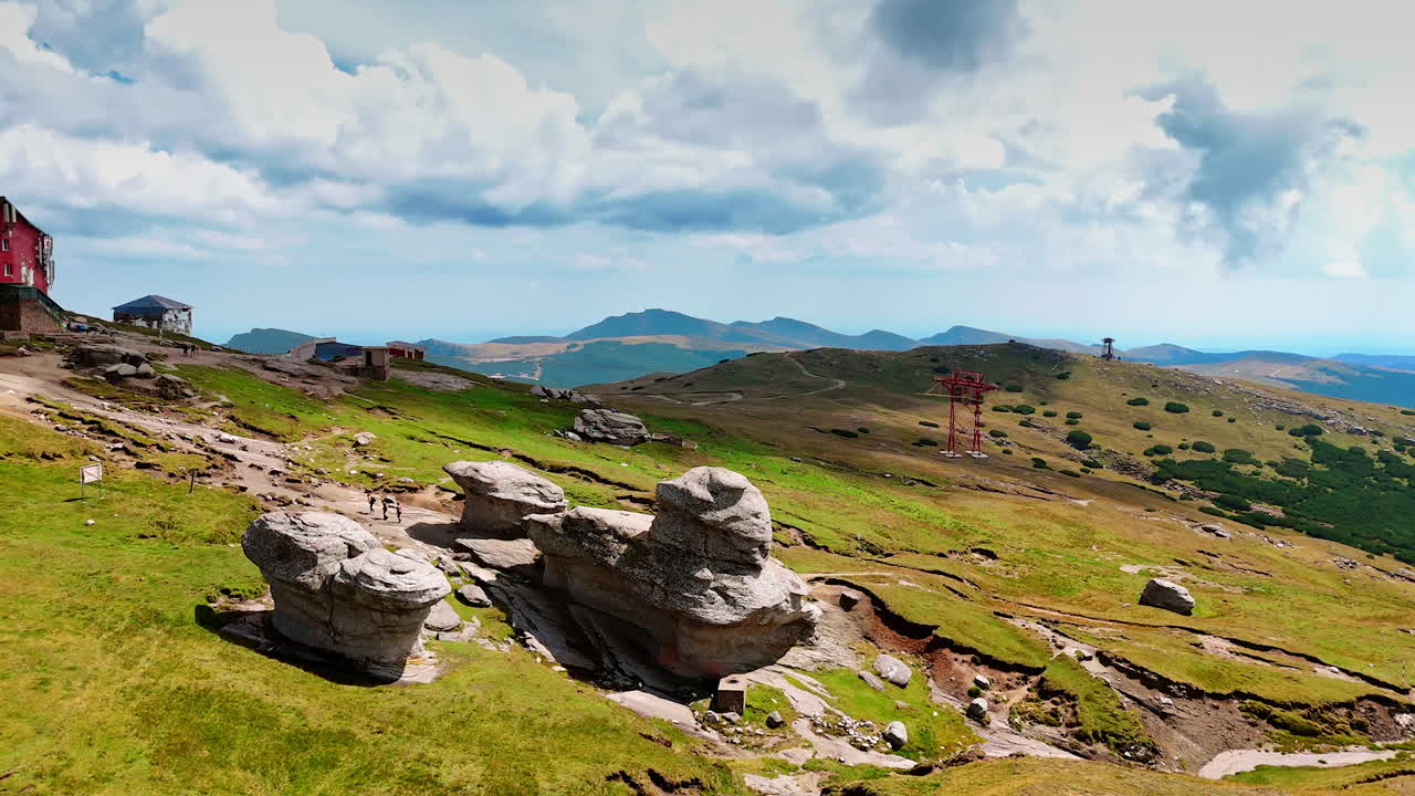 Green hills and rocky ridges of Caraiman Plateau. Rolling green hills and rocky ridges stretch across the plateau in Bucegi Mountains