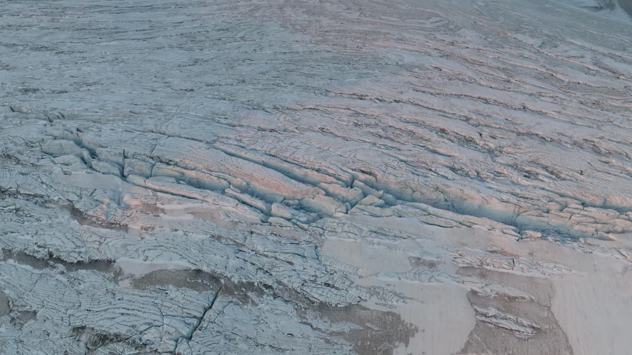 From a bird's-eye view, the glacier unfurls its labyrinthine crevasses and ridges, magnified by the upward motion of the drone