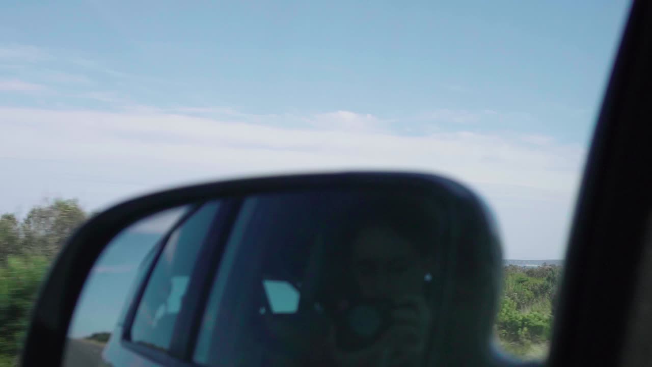 Rear Mirror View of car drive along Great Ocean Road, Victoria, Australia