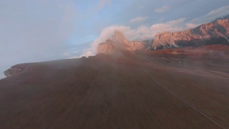 seceda dolomites, northeastern, italy - mountain ranges created by towering limestone called the dolomites and white foam clouds kissing the alps - drone footage