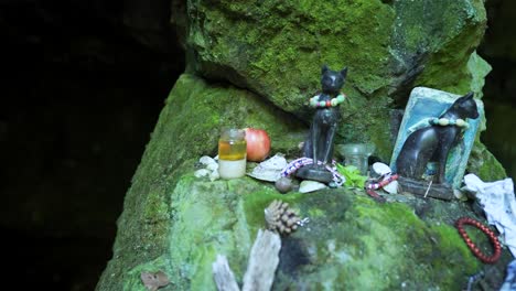 Offerings-and-relics-on-the-rocks-in-front-of-a-place-known-as-the-tomb-of-the-Egyptian-lioness-warrior-goddess-called-Bastet,-at-Strandzha-Mountain-in-Bulgaria