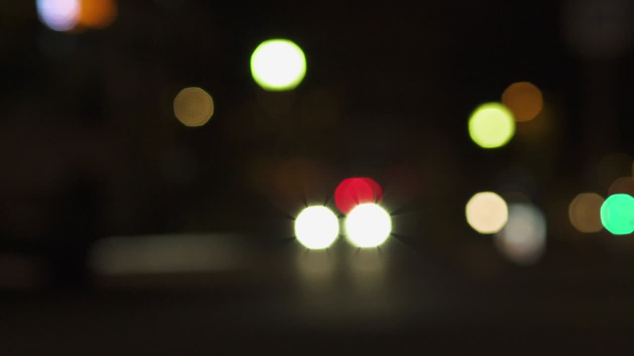 luces nocturnas desfocadas de la ciudad cerca de la torre eiffel en parís. color borroso bokeh de coches en movimiento y autobús en la calle. toma estática 4k uhd.