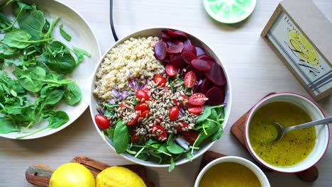 Luftaufnahme-Des-Salatdrehens-Auf-Einer-Rotierenden-Plattform,-Kürbiskerne,-Quinoa,-Rüben,-Tomaten,-Spinatblatt-Dressing