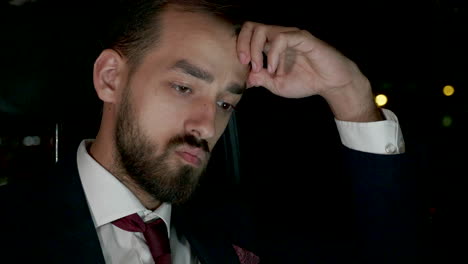 businessman working late in the back seat of his limousine