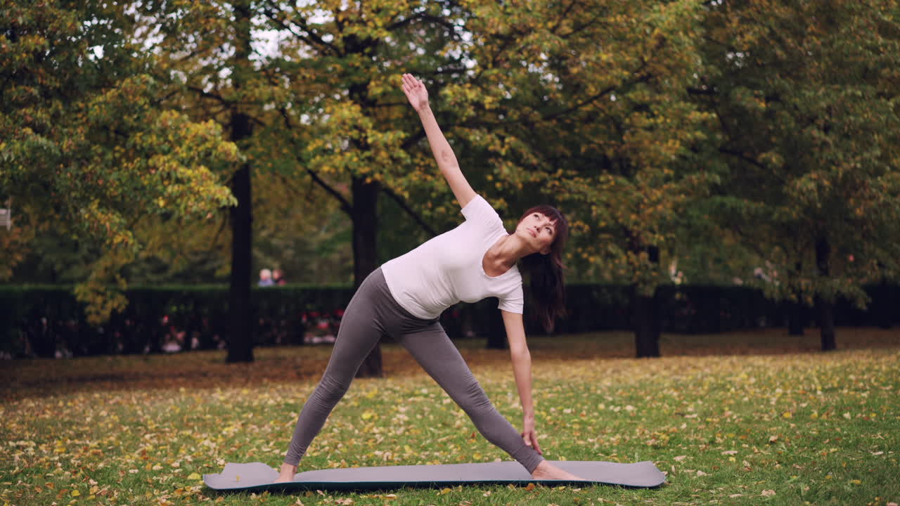 Woman practicing yoga in an autumn park