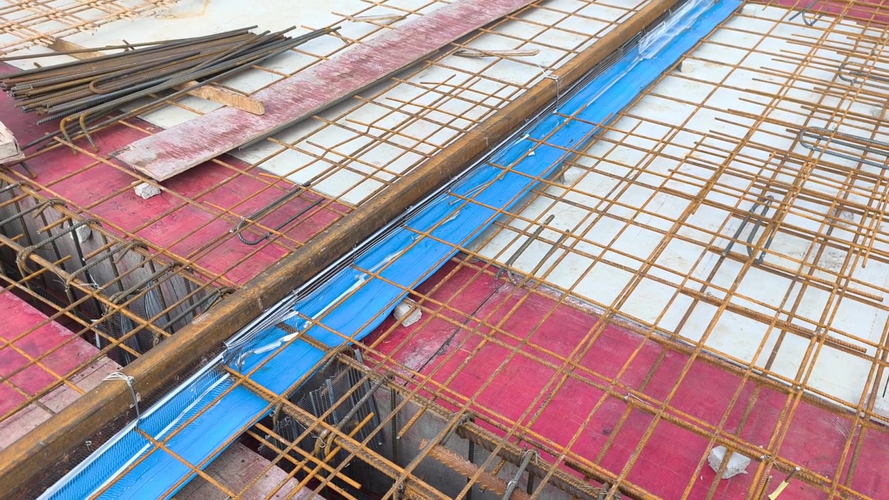 Sebuah Waterstop Karet Biru Dipasang di Sepanjang Sambungan Konstruksi Pelat Beton. Ini Berfungsi sebagai Penghalang untuk Mencegah Masuknya Air Melalui Sambungan Pelat Atap. Pemasangan Ini Memastikan Kedap Air Struktural