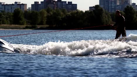 wake surfer riding board on river in sunny day. extreme lifestyle concept