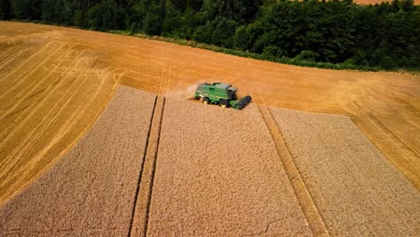 Aerial-view-of-agricultural-machine-cutting-the-grain-in-a-farmland